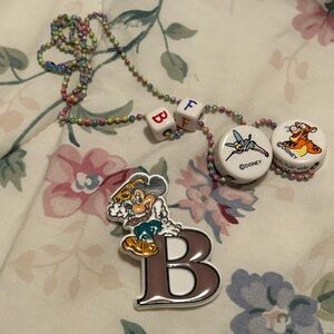 Disney charm necklace and pin bundle featuring Tink, Tigger, and Mickey Mouse